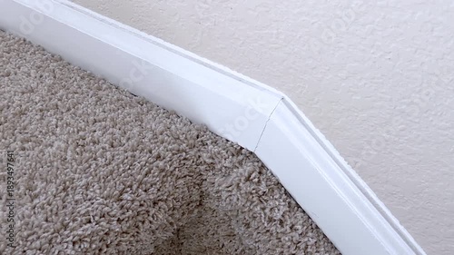 White trim on staircase corner above carpet