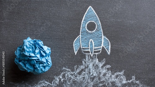 Business Startup and Innovation Concept with Chalk Rocket Drawing and Crumpled Paper on Blackboard