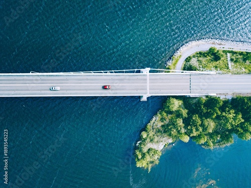 Φωτογραφία Aerial View of a Serene Bridge Stretching Over a Calm Body of Water Surrounded b
