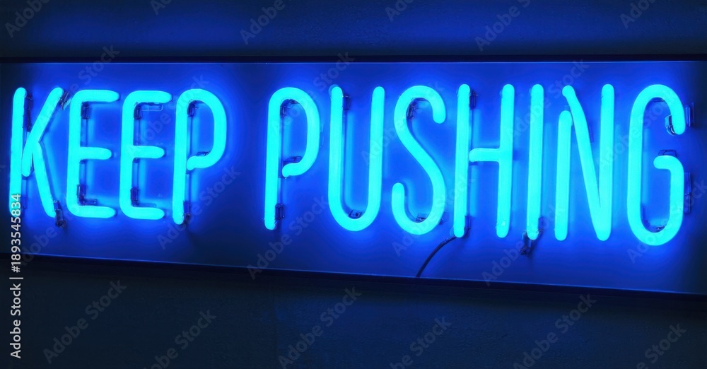 Fototapeta premium Bright blue neon sign displays motivational phrase. Dark background emphasizes glowing text, simple design.