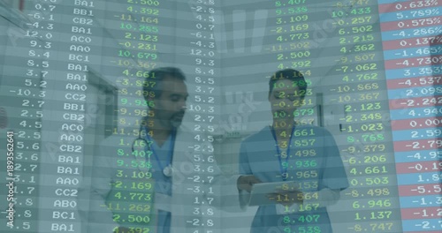 Doctor and nurse reviewing tablet in hospital corridor, visualizing medical finance data overlay