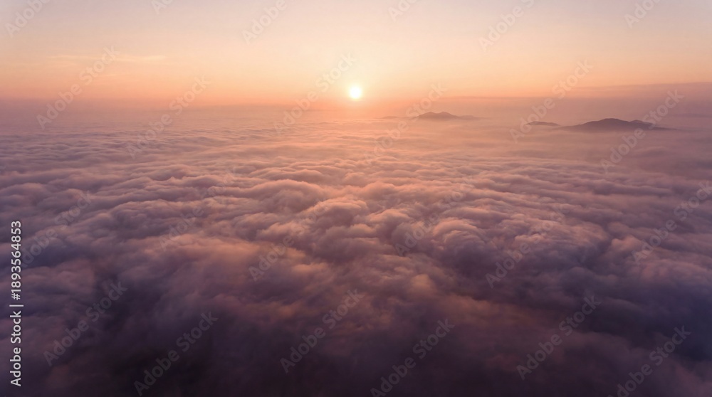 Fototapeta premium Sunrise over clouds with distant mountains viewed from above early in the morning