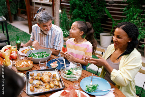 Multigenerational Family Sharing Food at Outdoor Dinner Table
