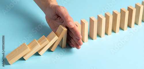 Hand verhindert, das weitere Dominosteine fallen