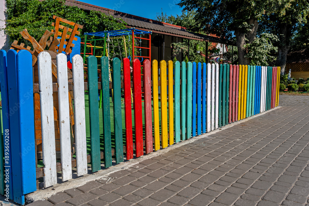 Fototapeta premium A colorful wooden fence in front of a building.