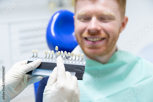 Dentist choosing veneers shade for smiling patient