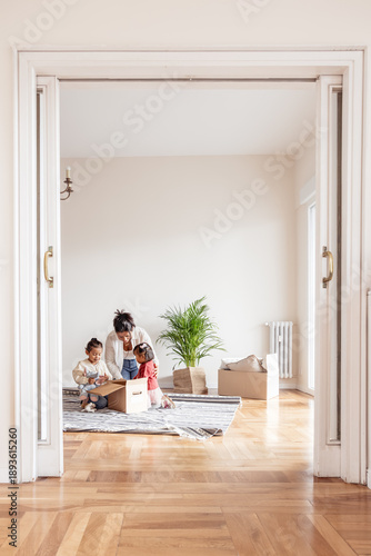 Family unpacking belongings in new home living room