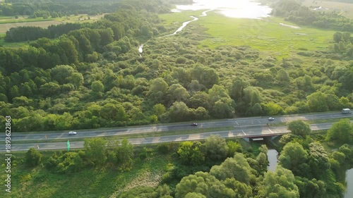 Scenic road through forest and wetland from above