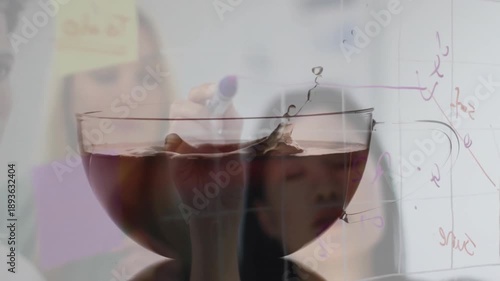 Team collaborating in science laboratory, watching liquid splash with animated purple diagrams