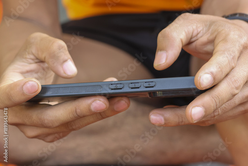 Bilde på lerret Focused gamer holding smartphone horizontally with intense grip playing mobile g