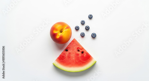 A vibrant arrangement of fresh fruit including a slice of watermelon, a peach, and blueberries on a clean white background.