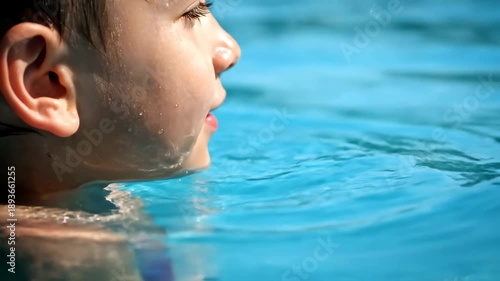 Close up profile of a young caucasian boy spitting water while playing in a swimming pool. Happy childhood moments and summer vacation activities. Sequence of frames for a web banner