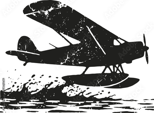 Vintage seaplane flying low over water with splashes in black silhouette