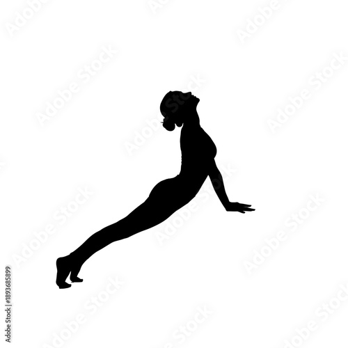 Silhouette of a woman practicing yoga in upward-facing dog pose.