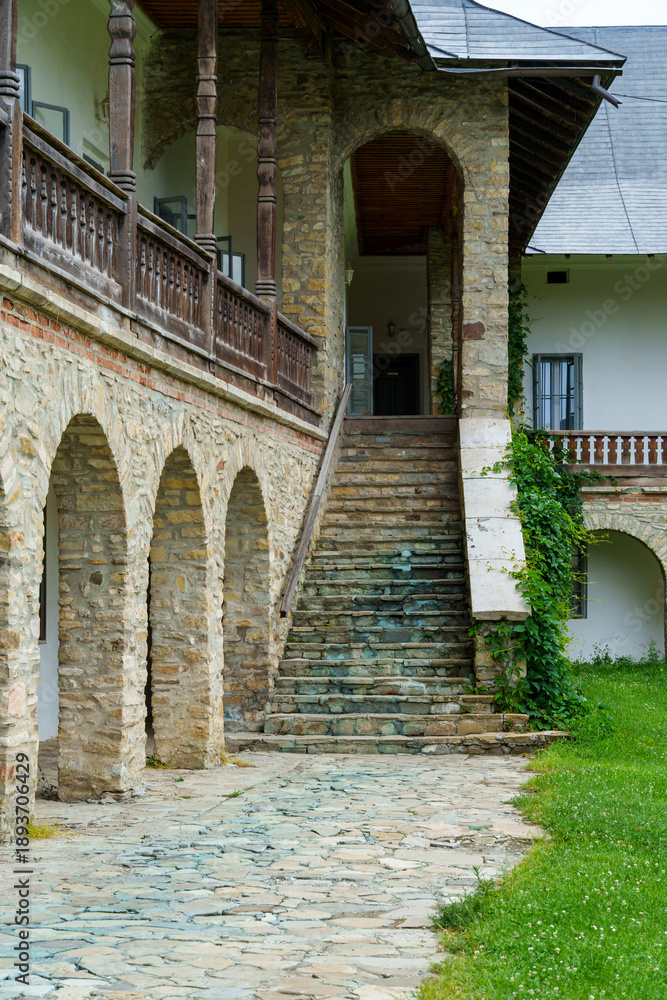 Naklejka premium view of the facade of an old house with a porch and arches