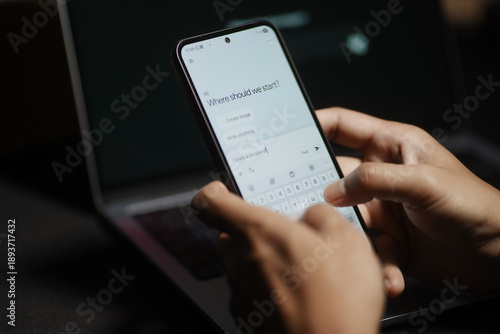 The hands of a man using a laptop or smartphone to operate artificial intelligence (AI), inputting commands and interacting with AI, AI assistants, chatbots, chatGPT.