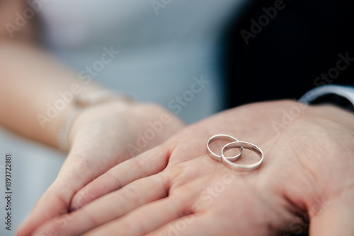 Slika na platnu A bride and groom gently hold their wedding rings in their hands, symbolizing love and commitment