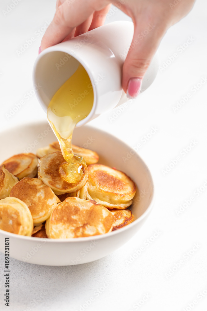 Fotografie Mini pancakes drizzled with honey