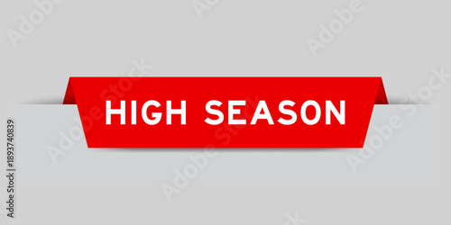 Red color inserted label with word high season on gray background