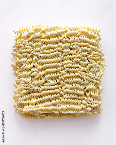Uncooked Asian instant ramen noodles on a white background. Dried ramen noodles, uncooked Korean ramen noodles. Close-up of the noodles.