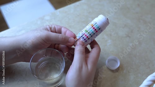 Wallpaper Mural A man in the kitchen tests tap water quality with a test strip. Home testing for drinking water safety, pH, chlorine, and chemical contaminants. Torontodigital.ca