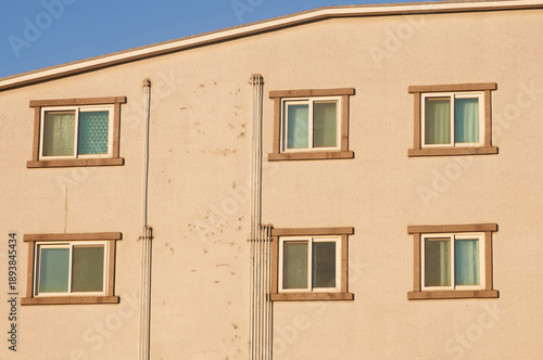 Sunlit Residential Building Facade With Repeating Windows