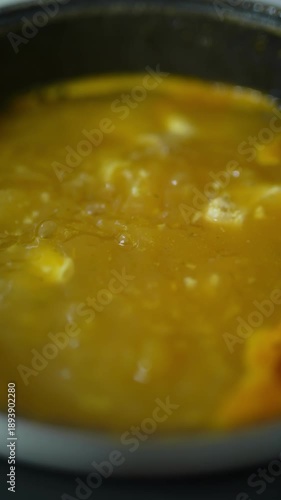 Chicken soup cooking in a saucepan. Slow motion. 