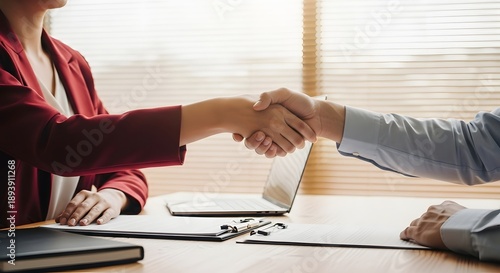 Two people shaking hands in an office.