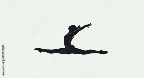 Graceful female gymnast performing a dynamic split in bright studio