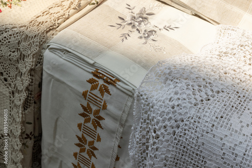 A close-up of vintage linen fabrics featuring brown embroidery patterns