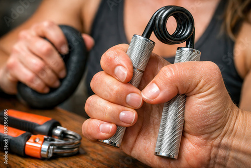 Hand grip trainer exercise forearm workout strength fitness focus on squeeze action with metal device on wooden table