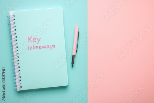 Mint green notebook with pink pen on pastel background