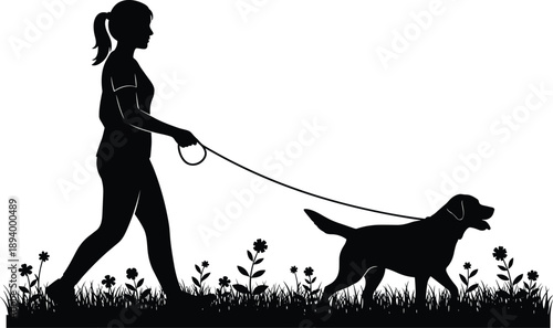 Black silhouette of a young woman walking her dog on a leash through a flower meadow, representing outdoor exercise, pet care, and healthy lifestyle.