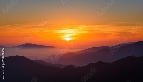 Wallpaper Mural a calming dawn breaking over a still mountain range with subtle shades of orange and yellow illuminating the sky Torontodigital.ca