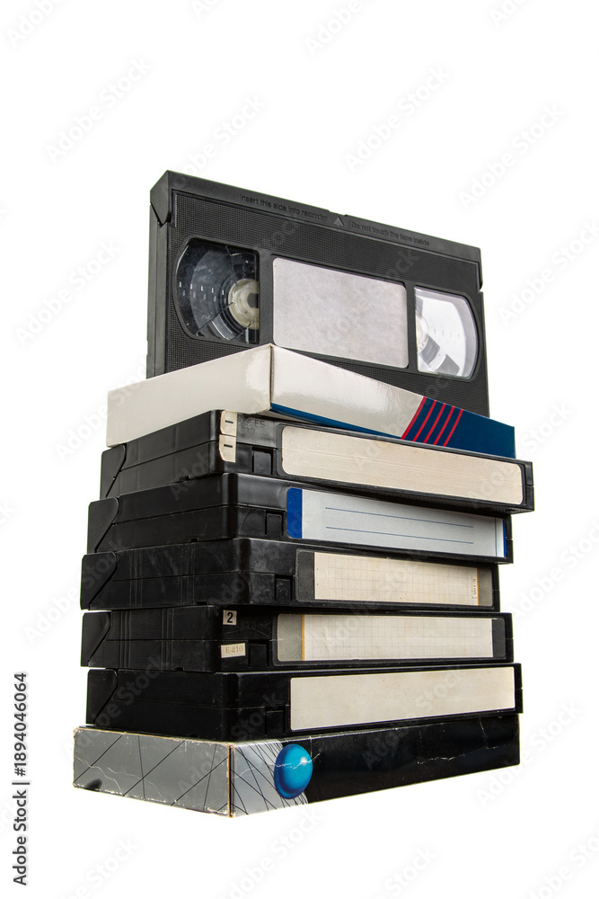 Obraz premium Stack of vintage black VHS video tapes with blank white labels isolated on white back