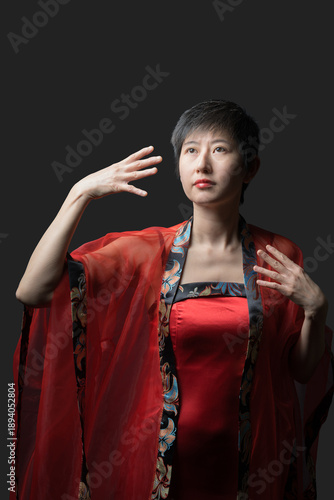 Chinese woman in red dress makes gestures with hands