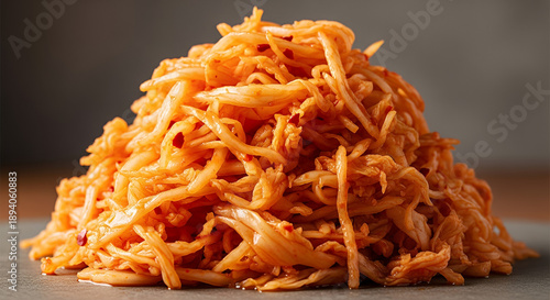 Translucent fermented cabbage in a vibrant orange hue, showcasing silky strands and a glossy appearance 