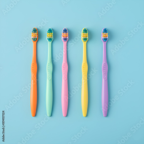 Wallpaper Mural High angle view of a row of five colorful toothbrushes in vibrant orange, mint green, pink, yellow, and purple colors arranged neatly on a solid bright blue background for dental hygiene Torontodigital.ca