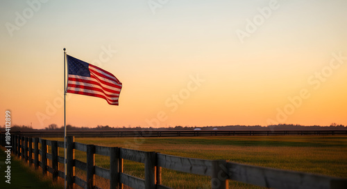 American Flag Waving at Sunset Over Rural Landscape with Wooden Fence