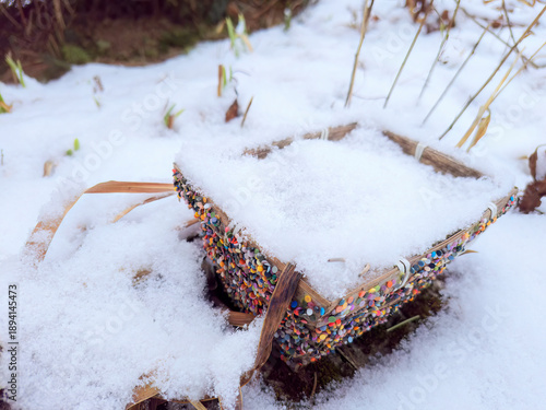 A wooden basket with colourful, little stones for decoration.