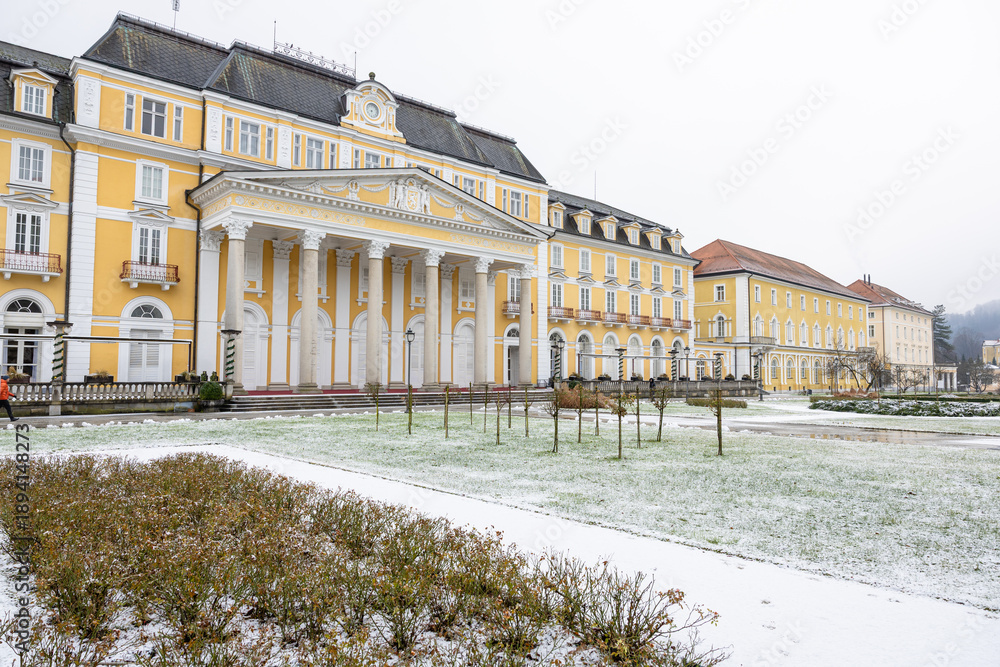 Naklejka premium Winter Scene Of A Yellow Historic SPA Building With Snow-Dusted Formal Garden In Town Square, Rogaska Slatina, Slovenia