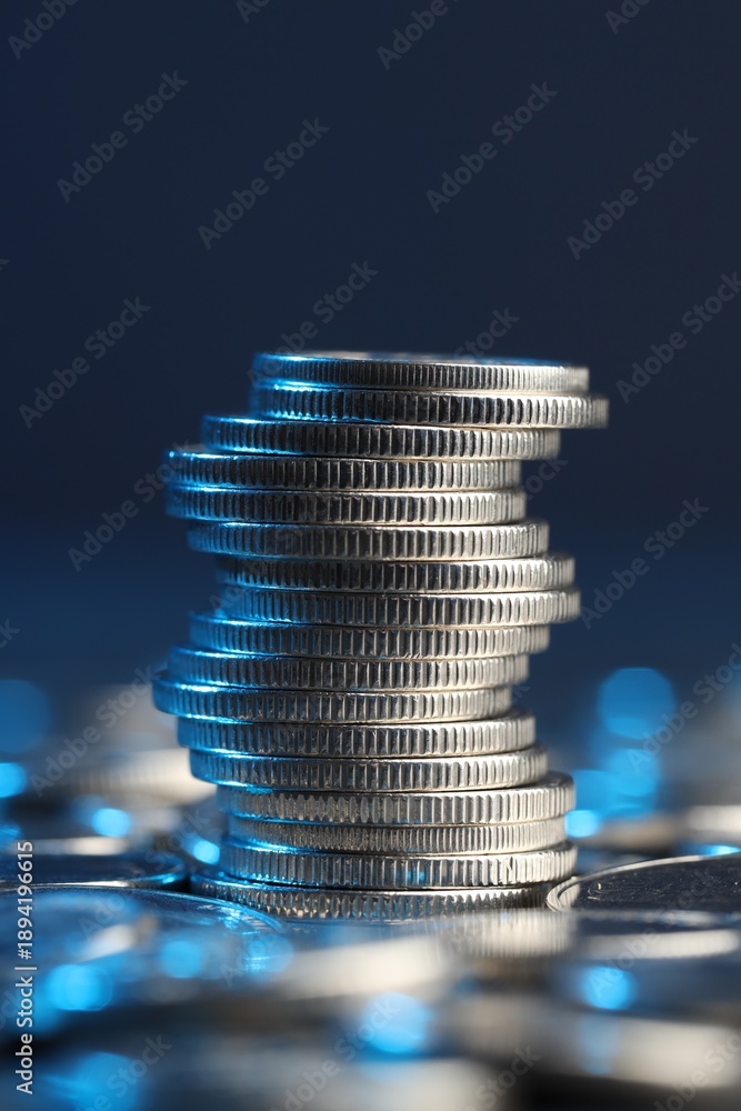 Naklejka premium Many stacked coins on table against blurred background, closeup