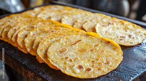 Freshly baked tandoor flatbreads with a crispy golden crust, laid in a row.