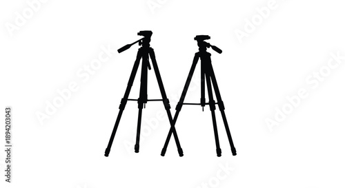 Two black tripods stand closely together a striking silhouette