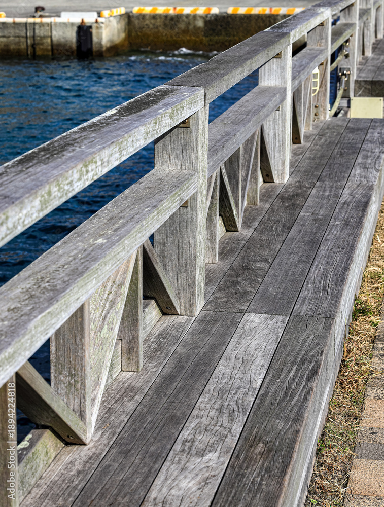 Obraz premium Wooden along the waterfront walkway. In the waterfront park.