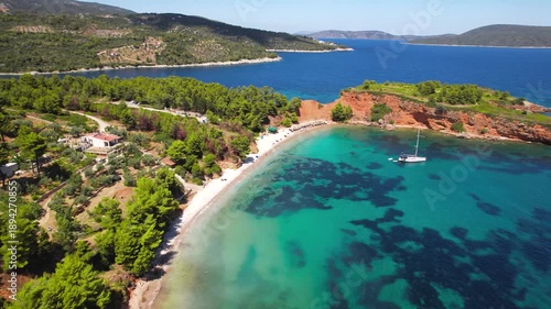 Aerial Cinematic Sequence Part 1: Low Drone Flyover of Kokkinokastro Beach — Vibrant Turquoise Water with ancored sailing boat and Golden Sands, Alonissos Marine Park Greece