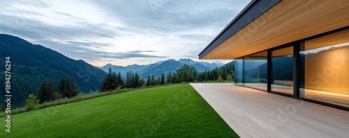 Modern mountain retreat with glass walls, showcasing panoramic alpine views and a manicured lawn. Architecture, Landscape, Luxury, Nature, Scenic, Vista