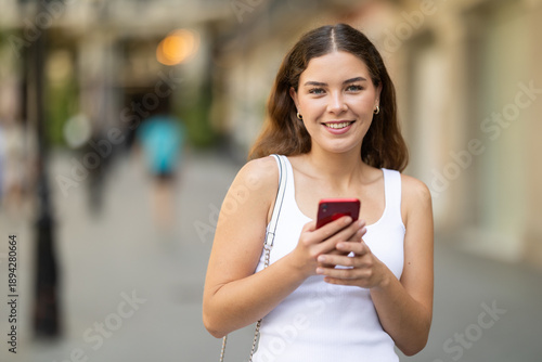Fotografie Smiling curious young girl around 20 years old stopping briefly while exploring
