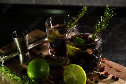 Delicious alcoholic cocktails made with rum, cola, and ice in glasses for relaxing at night and refreshing in the summer. Spices and green lime for flavor. Bartender and bar