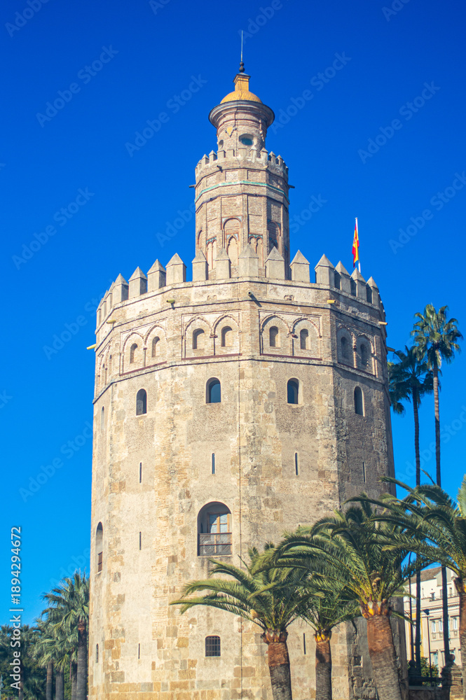 Fototapeta premium The iconic Golden Tower stands along the Guadalquivir River, reflecting centuries of maritime history in Sevilla, Spain.